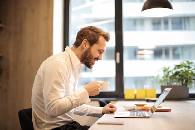 Utilizing Customer Feedback to Refine Marketing Approaches A man drinking coffee and using his laptop